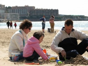 Una família jugant en una platja de la Costa Daurada.