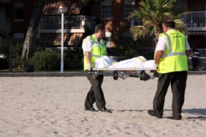 Moment de l'aixecament del cadàver de la dona morta aquest diumenge a la platja de Vilafortuny de Cambrils. Foto: ACN